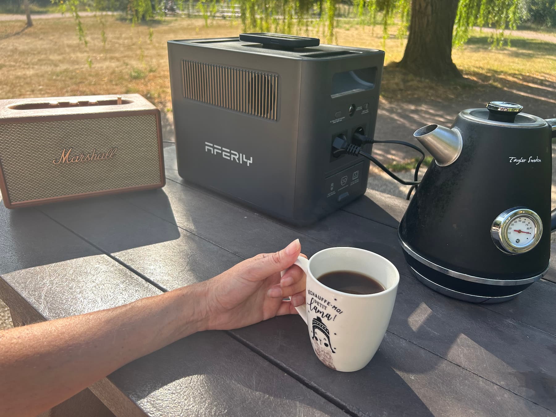 AFERIY Nomad1800 Pro alimentant une bouilloire et une enceinte Marshall Acton III sur une table de camping